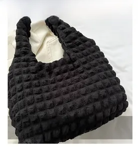 Close-up of black popcorn texture fabric on a minimalist pleated shoulder tote bag