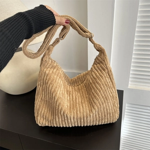 Close-up of khaki corduroy tote bag showing soft ribbed texture and adjustable strap