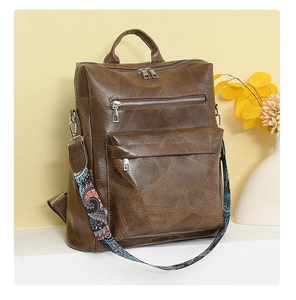 Detailed view of brown vintage leather backpack featuring colorful ethnic pattern strap