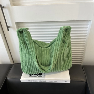Close-up of green corduroy tote bag showing thick ribbed texture and wide strap