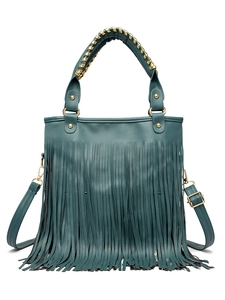 Detail view of dark teal handbag with dense tassels and gold woven metallic handle