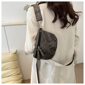 Detail van retro grijze crossbodytas met vintage textuur en brede etnische schouderband