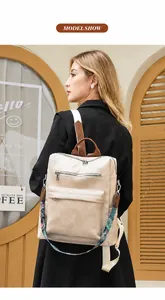 Detailed side view of beige leather backpack with decorative ethnic patterned strap