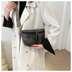 Détail d'un sac de poitrine gris vintage avec une large bandoulière brodée de style ethnique
