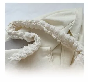 Close-up detail of white bubble texture pleats and soft handle on the cloud shoulder bag