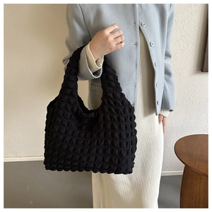 Detail of black pleated bubble texture tote bag showing soft 3D puffy fabric design