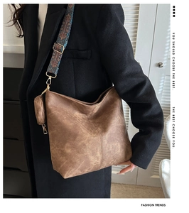 Close-up of retro brown bucket bag with wide jacquard strap and mini coin purse detail