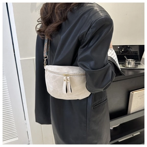 Détail du sac bandoulière crème avec sangle à motifs et fermeture éclair double