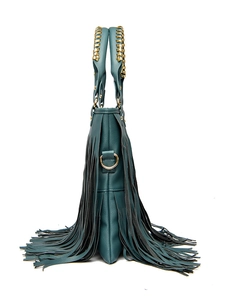 Detail of dark green handbag with long side tassels and gold woven handle accents
