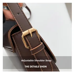 Close-up of adjustable brown leather shoulder strap with gold metal buckle and fine stitching