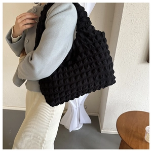 Detailed close-up of 3D bubble texture and soft fabric on the black tote bag