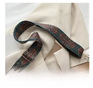 Detail of adjustable retro patterned shoulder strap with gold metal hooks on a blazer
