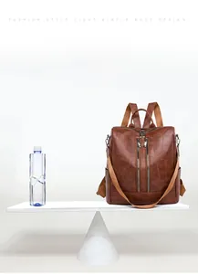 Brown vintage faux leather backpack weighing only 0.43kg shown on a balance scale