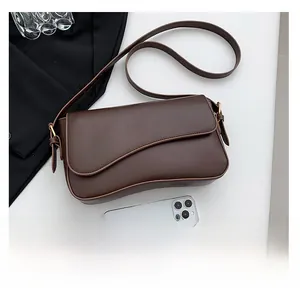 Detail view of brown leather shoulder bag with magnetic flap and adjustable strap