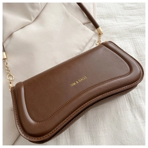 Close-up of brown leather bag with gold logo and elegant chain strap detail