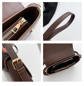 Detail view of dark brown leather shoulder bag with golden hardware and interior zip pockets