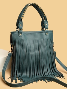 Detail of teal leather handbag with long fringe tassels and gold metallic accents