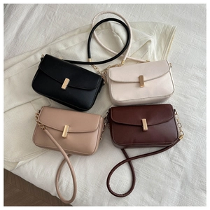 Flat lay of small rectangular shoulder bags in black, white, and brown with gold buckles