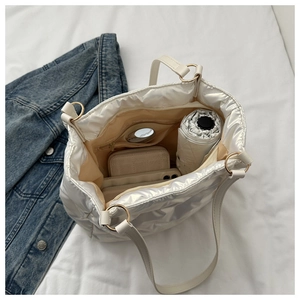 Vue intérieure du sac matelassé blanc montrant l'espace pour téléphone et portefeuille