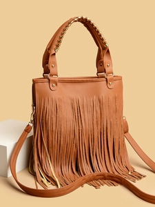 Detailed view of caramel tassel handbag with lychee texture and gold rivet hardware