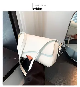 Close-up of white crossbody bag with flap magnetic closure and golden metal adjustment buckle