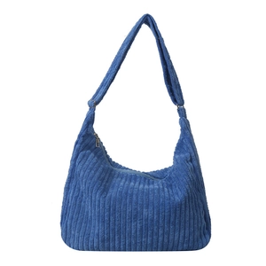Blue corduroy shoulder tote bag with vertical stripes and wide strap on white background