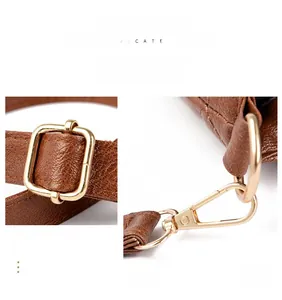 Détail du fermoir mousqueton doré et boucle réglable sur sac cabas en cuir marron