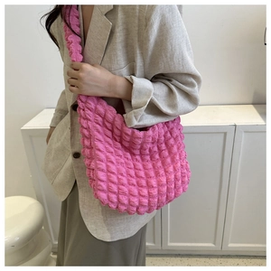Detail shot of pink popcorn textured shoulder bag showing the material and size fit