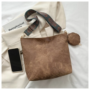 Detail of vintage brown suede bucket bag with geometric strap and mini round coin pouch