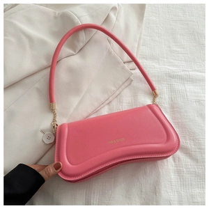 Close-up of pink leather shoulder bag featuring gold XM & BAGS logo and premium stitching