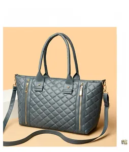 Détail du sac cabas matelassé gris avec zips dorés et bandoulière amovible