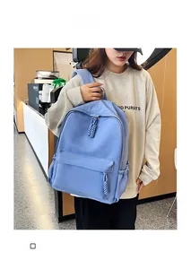 Close-up of light blue nylon backpack with woven zipper detail and side elastic pocket
