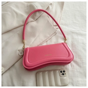 Detail of rose pink shoulder bag with gold XM & BAGS logo and leather texture