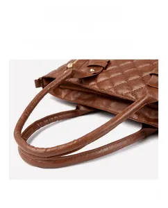 Détail du sac cabas matelassé marron avec poignées lisses et ferrures dorées