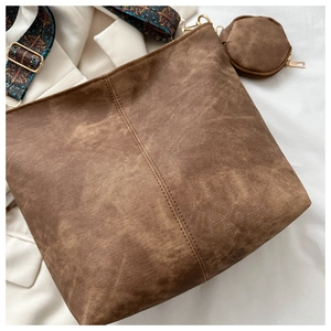 Detail view of brown vintage bucket bag with ethnic print strap and mini pouch