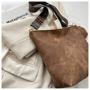 Detail of vintage brown bucket bag with ethnic pattern strap and mini pouch