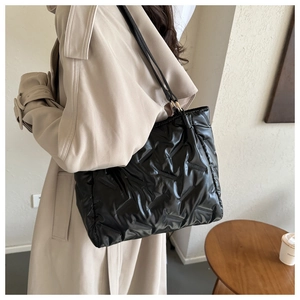 Détail du sac cabas matelassé noir brillant avec doubles bandoulières élégantes