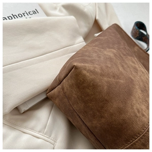 Detail of vintage bucket bag with contrast stitching and jacquard woven strap