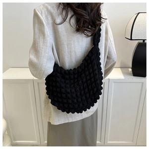 Detail of black cloud pleated shoulder bag showing 3D bubble texture and wide strap