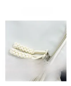 Detail view of smooth nylon backpack with durable double zippers and woven rope pullers