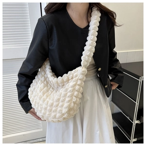 Detail of white popcorn textured fabric on the half-moon shoulder bag with soft strap