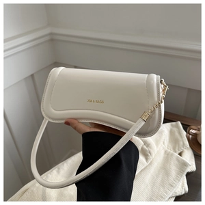 Detail of minimalist beige crossbody bag featuring gold chain and XM BAGS logo