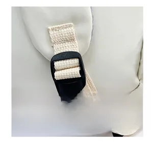 Close-up of adjustable shoulder strap with plastic buckle on a beige nylon backpack