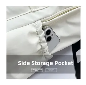 Detail view of the side elastic pocket on the white nylon backpack holding a smartphone