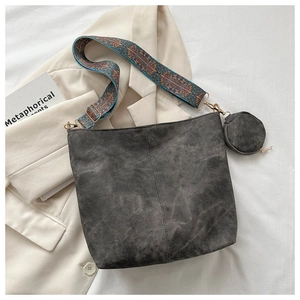 Detail of dark grey retro bucket bag featuring colorful jacquard woven strap and mini pouch