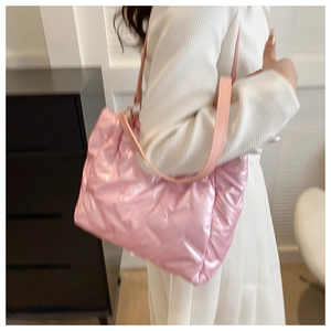 Détail d'un sac cabas rose matelassé avec finition métallisée et texture rembourrée
