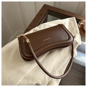 Detailed close-up of brown leather shoulder bag with gold chain strap and XM & BAGS logo
