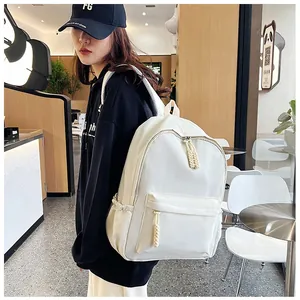 Detailed view of casual white nylon backpack worn by model showing its spacious design
