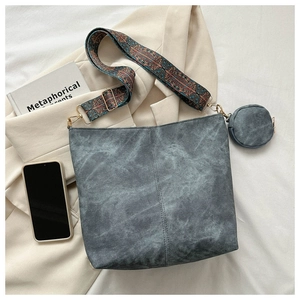 Detail of grey washed canvas bucket bag with ethnic woven strap and mini pouch