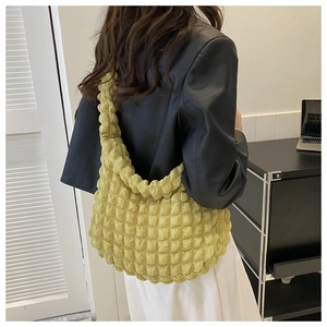 Detail of lime green bubble textured tote bag with 3D quilted fabric on model
